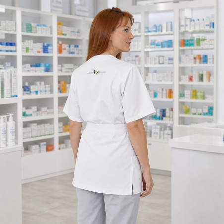 Blouse cache-cœur blanche portée en pharmacie — vue de dos, logo brodé