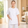 Blouse médicale femme blanche à liseré vert portée par une aide-soignante