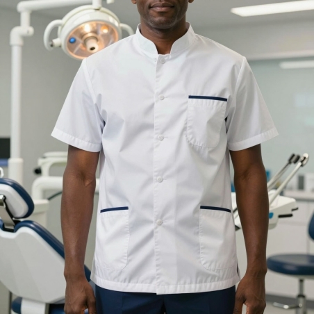 Dentiste en tunique médicale homme blanche à liseré marine dans son cabinet dentaire