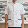 Pharmacien au comptoir de l'officine en tunique médicale homme blanche à liseré marine