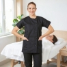 Esthéticienne en tunique médicale femme Julia noire dans une cabine de soin d’institut de beauté